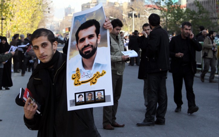  An Iranian man holds a poster of killed chemistry scientist Mostafa Ahmadi Roshan during his funeral ceremony in Tehran, Iran, 13 January 2012. Ahmadi Roshan was killed in a car bomb blast on 11 January when a motorcyclist attached a magnetic bomb on the car of Mostafa Ahmadi Roshan, which killed the chemistry scientist and injured two others in his car. A deputy in the Tehran governor office compared the incident to the assassination attempts in the last two years on three other Iranian scientists who also worked on nuclear projects.  EPA/ABEDIN TAHERKENAREH