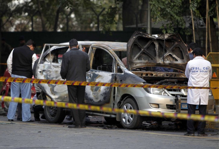 Indian security and forensic officials examine a car belonging to the Israel Embassy after an explosion in New Delhi, India, Monday, Feb. 13, 2012. An explosion tore through an Israeli diplomat's car on the streets of New Delhi on Monday, Israeli officials said. The driver and a diplomat's wife were injured, according to Indian officials. (AP Photo/Mustafa Quraishi)