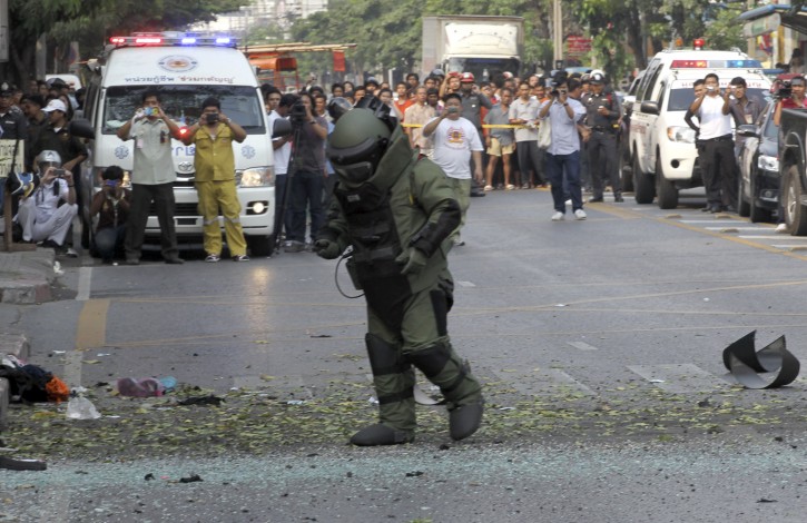 A Thai Explosive Ordnance Disposal (EOD) official examines the bomb site in Bangkok, Thailand Tuesday, Feb. 14, 2012. Thai police say two explosions have occurred in a Bangkok neighborhood. But it was not immediately clear what caused the blasts or wether there were an fatalities. (AP Photo/Apichart Weerawong)