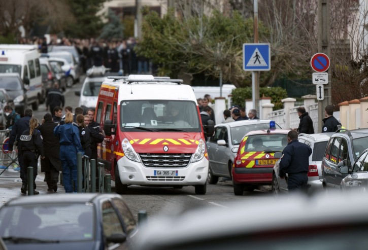 Police officers and firefighters gather at the site of a shooting in Toulouse, southwestern France, Monday, March 19, 2012. A shooter opened fire in front of a Jewish school killing a number of people, the Toulouse prosecutor said Monday. (AP Photo/Bruno Martin)