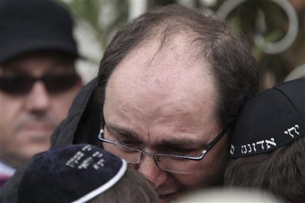 An unidentified man comforts schoolchildren as they leave their Jewish private school after a gunman opened fire killing several people in Toulouse, southwestern France, Monday, March 19, 2012. A father and his two sons were among four people who died Monday when a gunman opened fire in front of a Jewish school, the Toulouse prosecutor said Monday. (AP Photo)