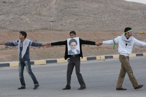 FILE - In this Tuesday, Nov. 25, 2011 file photo, Iranian students form a human chain near the Isfahan Uranium Conversion Facility in support of Iran's nuclear program, as one of them holds a poster of late revolutionary founder Ayatollah Khomeini, just outside the city of Isfahan, 410 kilometers, 255 miles south of the capital Tehran, Iran. While much is known about Iran's nuclear activities from U.N. inspection visits, significant questions remain uncertain, fueling fears of worst-case scenarios and calls for new Mideast military action.(AP Photo/Vahid Salemi, File)