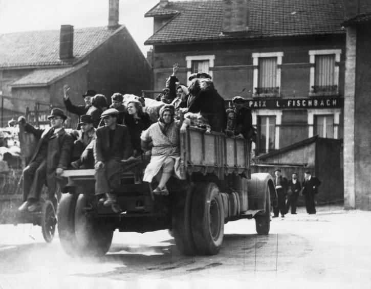 Fred Gross recently went on the Internet to find photos depicting Belgian refugees fleeing from the German invasion of Belgium in May 1940. Looking through hundreds of pictures that came up,  Fred noticed a photo of a truck transporting refugees to a French village. In his book, One Step Ahead of Hitler: A Jewish Child’s Journey through France, Fred writes about riding on such a truck with his family through Nazi bombardments along the coast lines of Belgium and France. The image turned out to be the truck as Fred recognized the two people sitting on the tailgate as his parents, Max, center, and Nacha, right. Then Fred noticed his two brothers: Leo partially blocked by a woman’s raised arm on the left side, front of truck; Sam, in front, right side and to the left of the word PAIX - meaning PEACE. The child with him is Fred.  (Photo by Keystone/Hulton Archive/Getty Images)