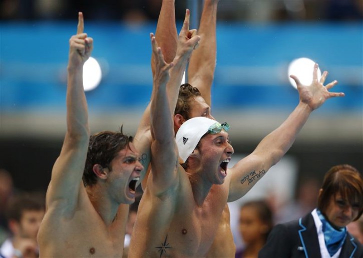 Members of France's 4x100m men's freestyle relay team Clement Lefert, Fabien Gilot and Amaury Leveaux cheer as their anchor Yannick Agnel swims the final leg, during the event final at the London 2012 Olympic Games at the Aquatics Centre July 29, 2012. Gilot and his Hebrew tattoo can be seen on his left arm. Photo: Reuters
