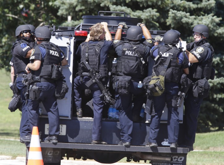 Police personnel move outside the Sikh Temple in Oak Creek, Wis, where a shooting took place Sunday, Aug. 5, 2012. (AP Photo/Jeffrey Phelps)