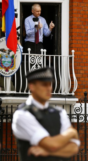 Wikileaks founder Julian Assange addresses the media and supporters while British policemen stand outside the Ecuadorian Embassy in London, Britain, 19 August 2012. Ecuador granted diplomatic asylum to Wikileaks founder Julian Assange who who took refuge inside the Ecuador's Embassy. EPA/KERIM OKTEN