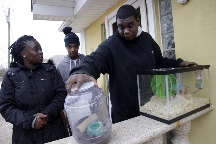 In this Nov. 1, 2012, photo, Gregory Labidou, right, tries to figure out what to do with his pet gerbils and tarantula after he was forced to evacuate his home because of damage from Superstorm Sandy in the Midland Beach section of Staten Island, New York. His aunt, Irmine Celestine, left, agreed to take the gerbils, but not the tarantula, until Labidou could find a more permanent place to stay. Superstorm Sandy drove New York and New Jersey residents from their homes, destroyed belongings and forced them to find shelter for themselves _ and for their pets, said owners, who recounted tales of a dog swimming through flooded streets and extra food left behind for a tarantula no one was willing to take in.  (AP Photo/Seth Wenig)