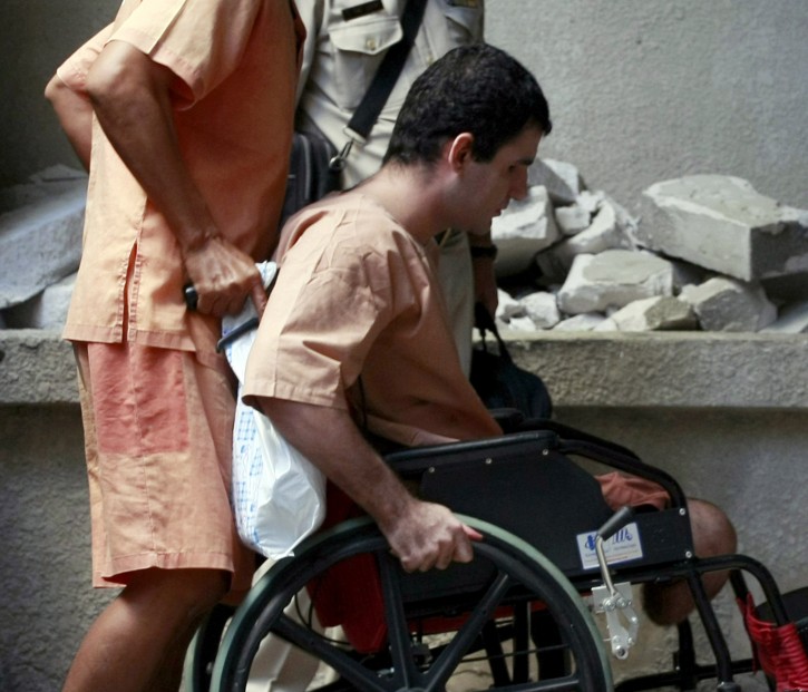 Saeid Moradi, an Iranian suspect bomber is pushed by a Thai prisoner on a wheelchair at criminal court in Bangkok, Thailand Friday, Dec. 21, 2012. Moradi, 28, was wounded with his own bomb after it exploded when he hurled it to a group of chasing Thai police officers. He and a compatriot Mohammad Kharzei were detained in Bangkok while another Iranian Masoud Sedaghatzadeh has been arrested in Malaysia after the series of explosion that occurred last February which wounded four other people. (AP Photo/Apichart Weerawong)