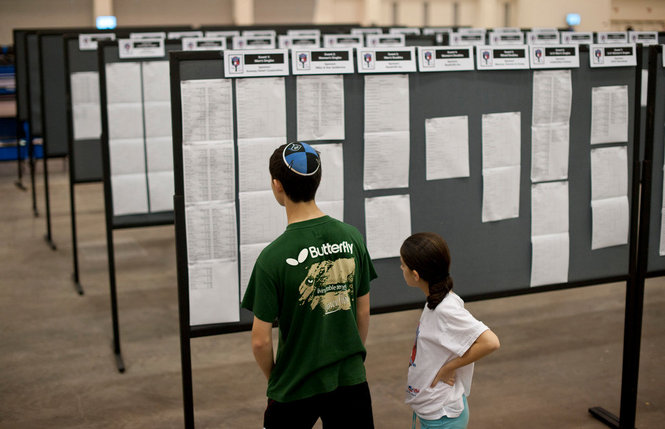 Akiva Ackerman, 13, and his sister, Estee Ackerman, 10, from New York, check the tournament bracket at the 2012 Table Tennis US Open Championships at Devos Place in Grand Rapids on Friday, June 29, 2012. Both competitors are ranked in their age groups in the US. They traveled to the tournament with their father Glenn Ackerman.(Grand Rapids Press /Landov/VINNews.com)