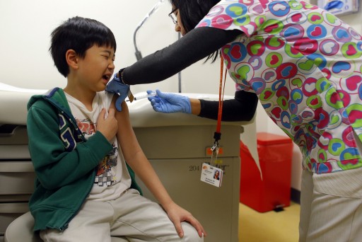 Chihn Ha, eight year old, gets an influenza vaccine injection from nurse Nho Nguyen (R) during a flu shot clinic at Dorchester House, a health care clinic, in Boston, Massachusetts January 12, 2013. REUTERS/Brian Snyder