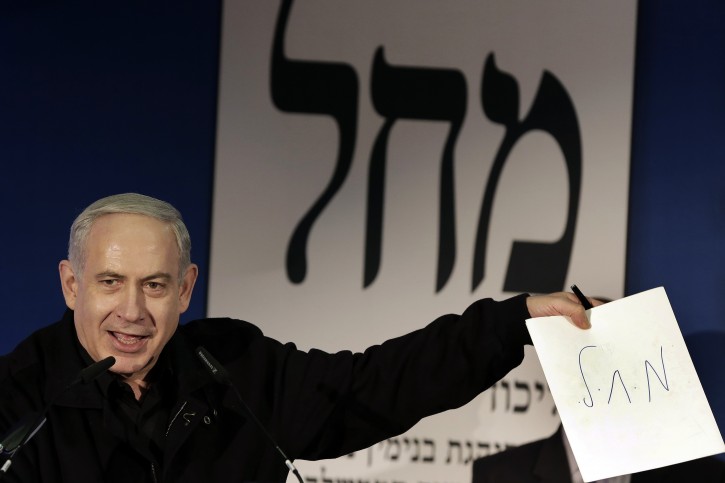 Israeli Prime MInister Benjamin Netanyahu holds up a paper after writing the Hebrew initials of the joint Likud - Yisrael Beitenu party as he addresses Russian immigrants during an election campaign stop in the port city of Ashdod, Wednesday, Jan. 16, 2013. Legislative elections in Israel will be held on Jan. 22, 2013. Netanyahu's right-wing Likud party, allied with the nationalist Yisrael Beitenu party, continues to lead opinion polls ahead of Israel's Jan. 22 parliamentary election. Photo by Tsafrir Abayov/Flash90