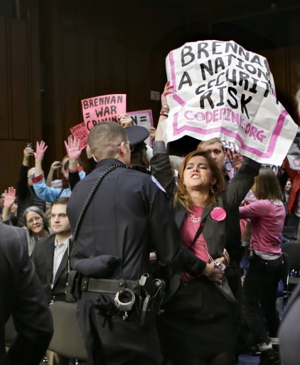 Protesters from CODEPINK, a social justice group opposed to U.S. funded wars, disrupt the start of a Senate Intelligence Committee's confirmation hearing for John Brennan, the top White House adviser on counterterrorism and nominee to lead the Central Intelligence Agency, Thursday, Feb. 7, 2013, on Capitol Hill in Washington. (AP Photo/J. Scott Applewhite)