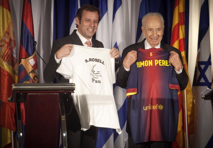 FC Barcelona president Sandro Rosell, left, and Israel's President Shimon Peres pose for photographers during a press statement at the Kfar Maccabiah sport center in Ramat Gan, Israel, Thursday, Feb. 21, 2013. Barcelona is trying to organize a match against a combined team of Palestinians and Israelis to promote peace. (AP Photo/Dan Balilty)