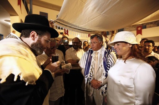 FILE - A rabbi blesses a glass of wine during a Jewish wedding ceremony at the El Ghriba synagogue on the Tunisian island of Djerba May 10, 2012. Reuters