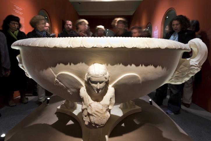 Visitors look at the large marble and plaster basin excavated from the lower Herodium fortress as they view the Israel Museum exhibition entitled, 'Herod the Great: The King's Final Journey,' as the show opens in Jerusalem, 12 February 2013. EPA/JIM HOLLANDER