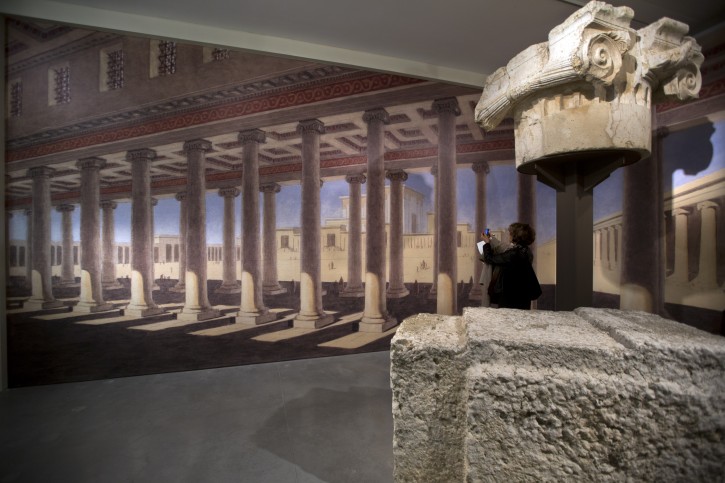 A visitor under a column capital and a huge stone that was part of the original Temple in Jerusalem that is part of the Israel Museum exhibition entitled, 'Herod the Great: The King's Final Journey,' as the show opens in Jerusalem, 12 February 2013. 