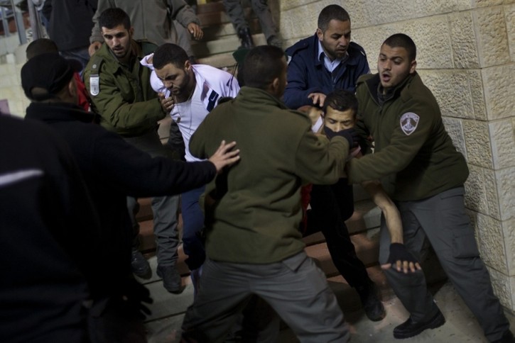 Israeli security forces detain Bnei Sakhnin supporters during a game against Beitar Jerusalem F.C. at the Teddy Stadium in Jerusalem, Sunday, Feb. 10, 2013. (AP Photo/Bernat Armangue)