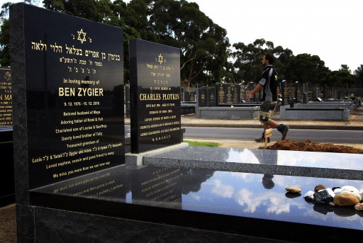 A workman walks through a Jewish cemetery, past the grave of Ben Zygier (L), the Australian which local media have identified as the man who died in an Israeli prison in 2010 and who may have been recruited by Israeli intelligence agency Mossad, in Melbourne February 14, 2013. Reuters