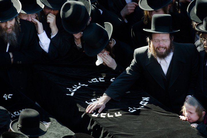 Members of the Satmar Orthodox Jewish community grieve over the coffins at the funeral for two expectant parents who were killed in a car accident, Sunday, March 3, 2013, in the Brooklyn borough of New York. A driver struck the car early Sunday morning, killing both parents while their baby, who was born prematurely, survived and is in critical condition. (AP Photo/John Minchillo)