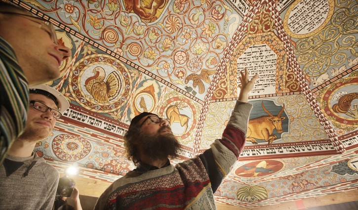 Boaz Pash,right, a rabbi based in Krakow,Poland, looks along with others at a the painted ceiling of a reconstructed wooden synagogue that dates back centuries, in Warsaw, Poland, on Tuesday March 12, 2013. The reconstructed ceiling and roof of the 17th century synagogue is a key attraction in the Museum of the History of Polish Jews, a major institution due to open next year in Warsaw.(AP Photo/Czarek Sokolowski)