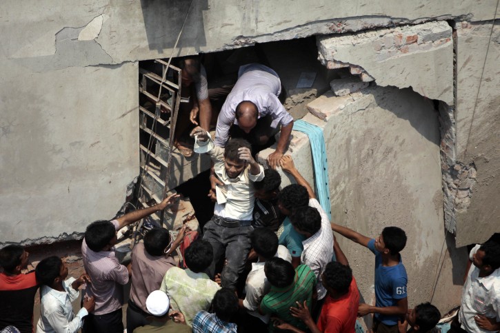 A man who was trapped is rescued after an eight-story building housing several garment factories collapsed in Savar, near Dhaka, Bangladesh, Wednesday, April 24, 2013. Dozens were killed and many more are feared trapped in the rubble. (AP Photo/ A.M. Ahad)