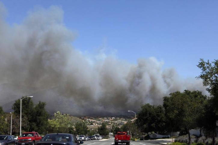 Plumes of smoke from a fast moving brush fire billow above the Newbury Park area of Ventura County May 2, 2013. A wind-driven brush fire raging northwest of Los Angeles prompted the evacuation of hundreds of homes and a university campus on Thursday as flames engulfed several recreational vehicles and crept toward housing subdivisions. REUTER/Patrick T. Fallon 