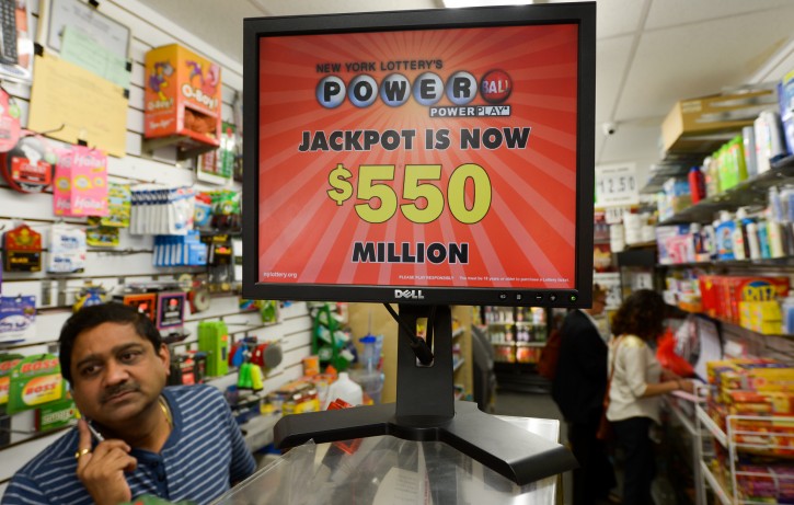  People are seen with a sign for the Powerball lottery in New York, New York, USA, 16 May 2013. The jackpot for the multistate US Powerball lottery rose to 550 million US dollars. It is the second-largest lottery prize in US history, according to the Iowa-based Powerball, a consortium of state government lottery agencies. The giant pot built up after 16 consecutive drawings without a winner. The chances of winning are one in 175 million.  EPA/JUSTIN LANE