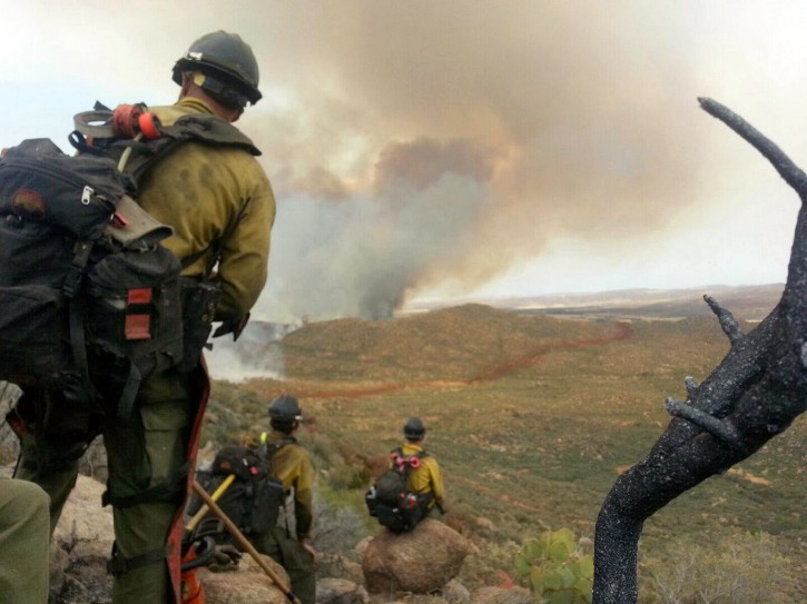 In this photo shot by firefighter Andrew Ashcraft, members of the Granite Mountain Hotshots watch a growing wildfire that later swept over and killed the crew of 19 firefighters near Yarnell, Ariz., Sunday, June 30, 2013. Ashcraft texted the photo to his wife, Juliann, but died later that day battling the out-of-control blaze.  The 29-year-old father of four added the message, "This is my lunch spot...too bad lunch was an MRE." (AP Photo/Courtesy of Juliann Ashcraft)