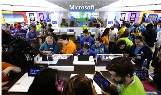 In this Thursday, June 20, 2013, photo, people crowd the aisles during the grand opening of a Microsoft retail store in downtown Portland, Ore. Microsoft Corp. reports quarterly financial results after the market closes on July, 18, 2013. (AP Photo/Don Ryan)