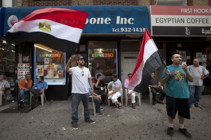 Men wave Egyptian flags on the street in the Queens borough of New York, July 3, 2013. Egypt's armed forces overthrew elected Islamist President Mursi on Wednesday and announced a political transition with the support of a wide range of political, religious and youth leaders.   REUTERS/Carlo Allegri 