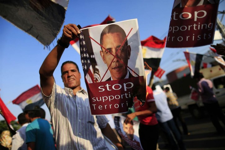 Opponents of Egypt's Islamist President Mohammed Morsi burn pictures showing the United States President Barack Obama during a rally outside the presidential palace in Cairo, Egypt, on July 7, 2013. (Hassan Ammar / AP)