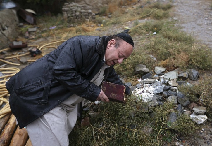 Zabulon Simantov, an Afghan Jew, prays at a Jewish cemetery in Kabul November 5, 2013. In his 50s, Simintov is the last known Afghan Jew to remain in the country. He has become something of a celebrity over the years and his rivalry with the next-to-last Jew, who died in 2005, inspired a play. Picture taken November 5, 2013. REUTERS/Omar Sobhani 