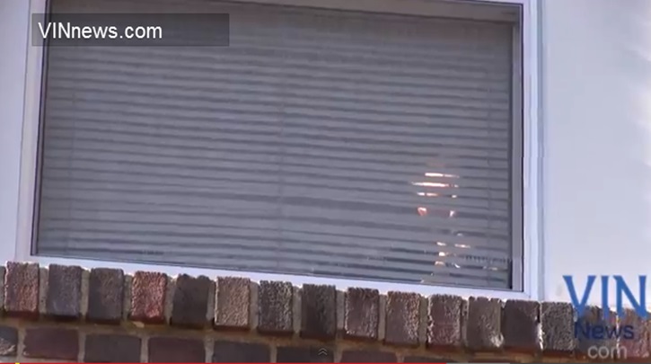 pilaj Palij looking out of the window of his home while the protest was ongoing