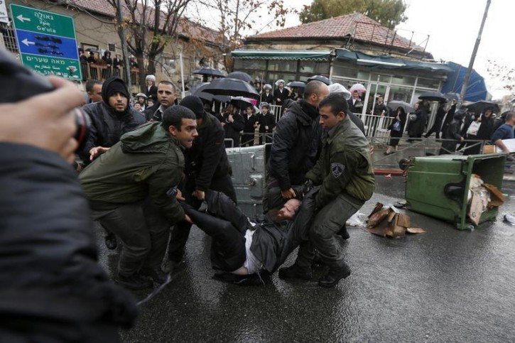 An ultra-Orthodox Jewish protester is detained by Israeli border policemen during clashes in Jerusalem's Mea Shearim neighbourhood December 5, 2013.  REUTERS/Baz Ratner