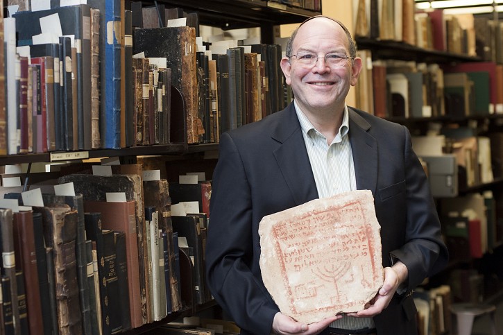 Dr. Steven Fine, professor of Jewish history and director of the Yeshiva University Center for Israel Studies, with ancient Biblical tombstone. It's a limestone gravestone from Zoar, a biblical city along the southeastern shore of the Dead Sea, which bears Aramaic inscriptions that preserve evidence of life among the Christian majority and Jewish minority that peacefully coexisted there in the fifth century. The stone is from 430 C.E. -- some 360 years after the destruction of the Second Temple.(credit to Yeshiva University)