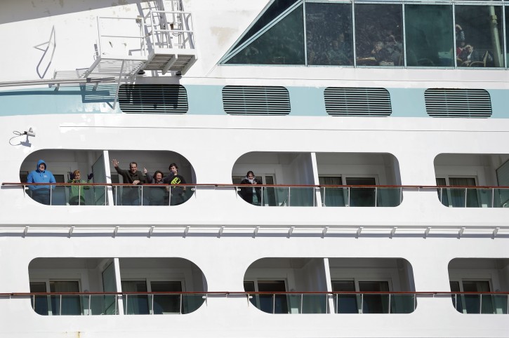 People look out from the Explorer of the Seas cruise ship as it docks at a berth, Wednesday, Jan. 29, 2014, in Bayonne, N.J. The number of passengers and crew reported stricken ill on the cruise ship has risen to nearly 700. The U.S. Centers for Disease Control and Prevention said Wednesday its latest count puts the number of those sickened aboard the Explorer of the Seas at 630 passengers and 54 crew members. (AP Photo/Mel Evans)