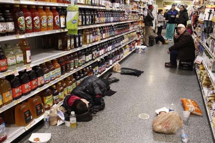 People rest at the aisle of a Publix grocery store after being stranded due to a snow storm in Atlanta, Georgia, January 29, 2014. A rare winter storm gripped the U.S. South on Wednesday, killing five people, stranding children overnight at their schools, gnarling traffic across many states and canceling flights at the world's busiest airport.    REUTERS/Tami Chappell 