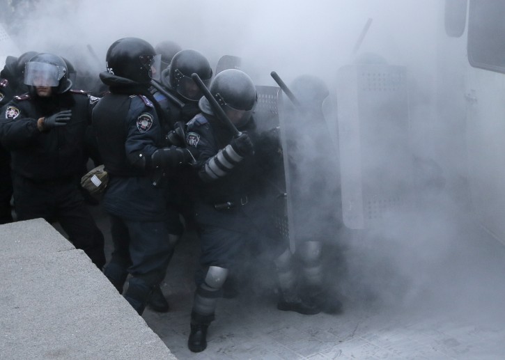 Riot police clash with protesters in central Kiev, Ukraine, Sunday, Jan. 19, 2014. Hundreds of protesters on Sunday clashed with riot police in the center of the Ukrainian capital, after the passage of harsh anti-protest legislation last week seen as part of attempts to quash anti-government demonstrations. A group of radical activists began attacking riot police with sticks, trying to push their way toward the Ukrainian parliament building, which has been cordoned off by rows of police and buses. (AP Photo / Efrem Lukatsky)