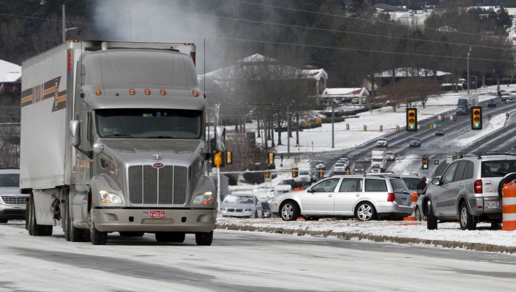 Icy conditions and abandoned  vehicles has traffic at a stand still along Highway 280 on Wednesday, Jan. 29, 2014, in Inverness, Ala. A Winter storm caught much of Alabama off guard and stranded thousands of people at work, schools and on roadways. (AP Photo/Butch Dill)