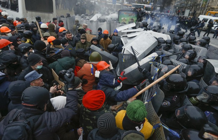 Protesters clash with riot police (R) during their protest in downtown Kiev, Ukraine, 19 January 2014.  Violence broke out 19 January at anti-government protests as hundreds of opposition supporters armed with clubs tried to break through a police blockade and storm the Ukrainian parliament. The demonstrations took on a sharper tone after last week's passage of new laws that protesters and human rights groups said are designed to stifle dissent. They criminalize libel, establish new penalties for unlawful protests and make it easier to strip legislators of their immunity.  EPA/SERGEY DOLZHENKO