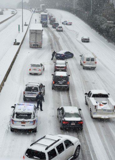 Traffic along Independence Boulevard near Hawthorne Lane crawls along the slick roadway as a winter storm hits   Wednesday, Feb. 12, 2014, in Charlotte, N.C. (AP Photo/The Charlotte Observer, Davie Hinshaw) 