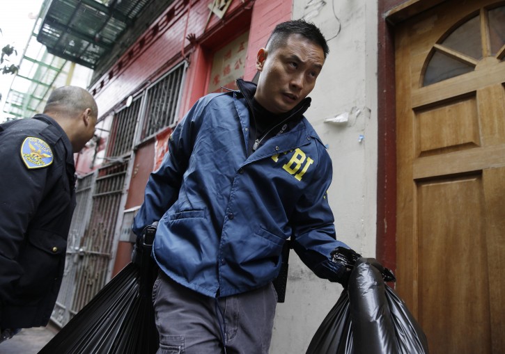 An FBI agent carries away bags of evidence following a search of a Chinatown fraternal organization Wednesday, March 26, 2014, in San Francisco. A California state senator was arrested Wednesday during a series of raids by the FBI in Sacramento and the San Francisco Bay Area, authorities said. An FBI spokesman confirmed the arrest of State Sen. Leland Yee, but declined to discuss the charges, citing an ongoing investigation. (AP Photo/Eric Risberg)