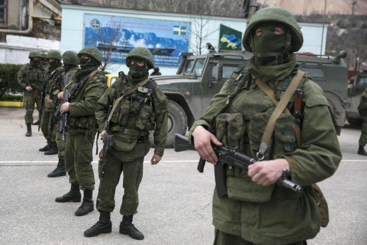 Armed servicemen stand near Russian army vehicles outside a Ukrainian border guard post in the Crimean town of Balaclava March 1, 2014.  Reuters