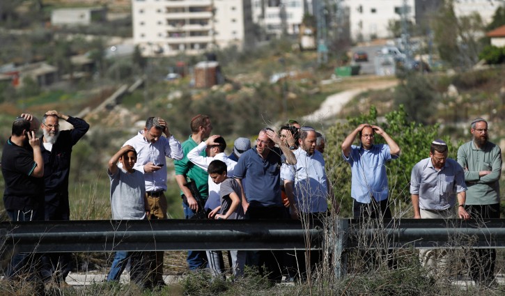Israeli settlers stand near the main road leading from the West Bank town of Ramallah to the Jalazun refugee camp, next to the Israeli settlement of Bet- El, 07 March 2014. Some of the settlers threw stones at a Palestinian Photographer Abbas Momani and damaged his car, the Photographer was lightly injured in the confrontations.  EPA/ATEF SAFADI