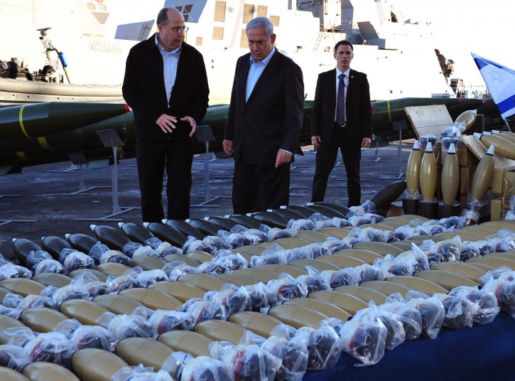A photograph supplied by the Israeli Ministry of Defense shows Israeli Prime Minister Benjamin Netanyahu speaking with his Defense Minister, Moshe Ya'alon (L) as they look at a stock pile of weapons including 181 122 mm mortar shells (below and right) and 40 Syrian-made M-302 missiles (behind), as well as approximately 400,000 7.62 caliber bullets (not pictured) on a pier in Eilat, southern Israel, 10 March 2014. EPA