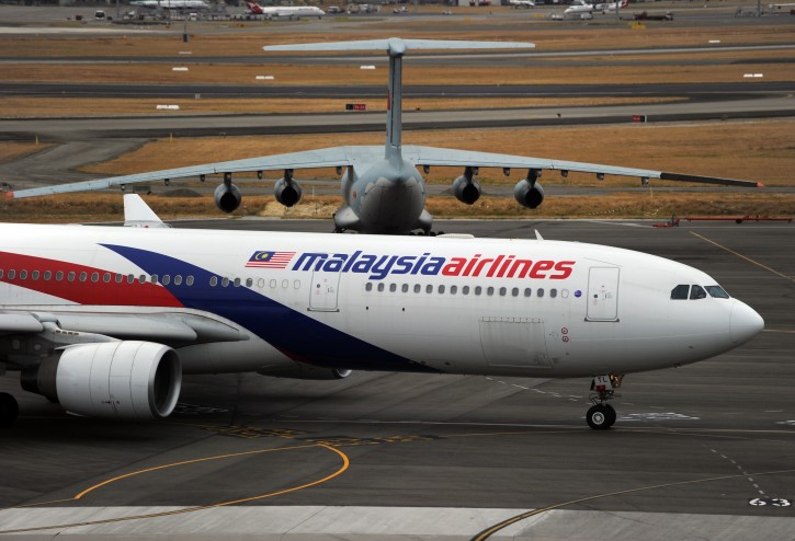 Malaysia Airlines plane (front) prepares to taxi and passes by a stationary Chinese Ilyushin 76 aircraft (background) at Perth International Airport, Australia, Tuesday, March 25, 2014. EPA