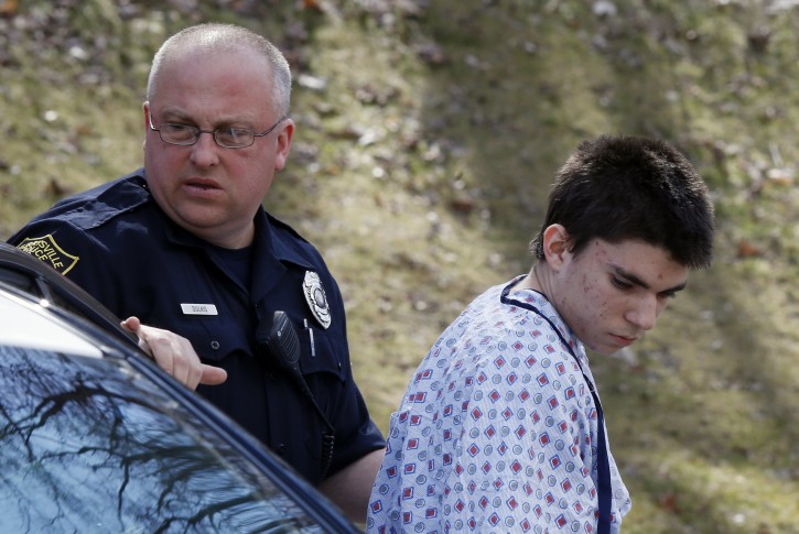 Alex Hribal, the suspect in the multiple stabbings at the Franklin Regional High School in Murrysville, Pa., is escorted by police to a district magistrate to be arraigned on Wednesday, April 9, 2014, in Export, Pa. Authorities say Hribal has been charged after allegedly stabbing and slashing at least 19 people, including students, in the crowded halls of his suburban Pittsburgh high school Wednesday. (AP Photo/Keith Srakocic)