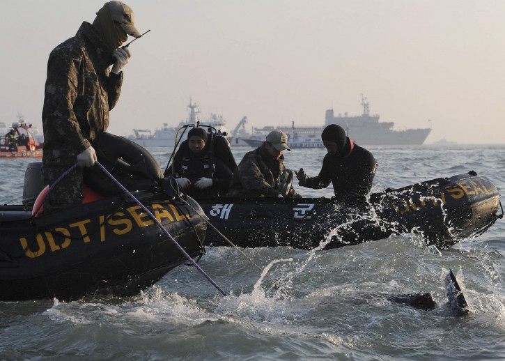 Divers look for people believed to have been trapped in the sunken ferry Sewol near buoys which were installed to mark the vessel in the water off the southern coast near Jindo, south of Seoul, South Korea, Wednesday, April 23, 2014.  AP