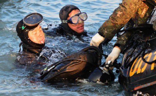File: Divers emerge from water after conducting an underwater search and rescue operation at the ferry Sewol's sinking site off the island of Jinju on South Korea's southwestern coast 23 April 2014. EPA/YONHAP