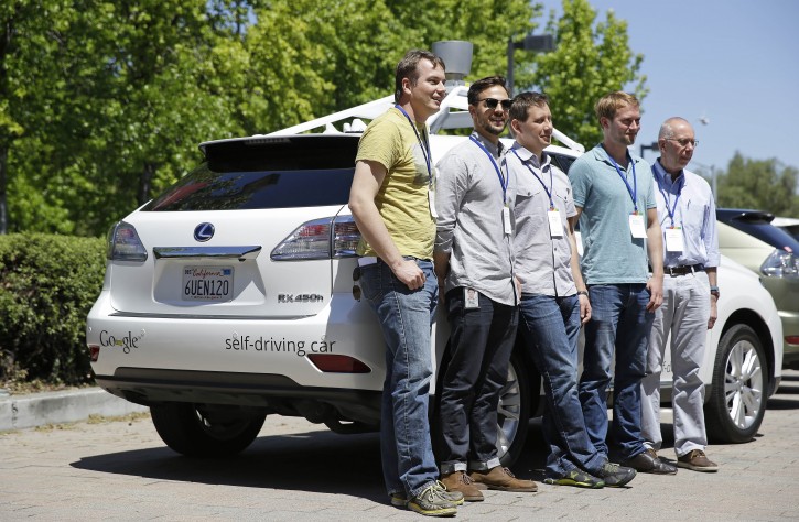 In this photo taken Wednesday, May 14, 2014, Google team members pose by a Google self-driving car at the Computer History Museum in Mountain View, Calif. From left is project direct Chris Urmson, Brian Torcellini, Dimitri Dolgov, Andrew Chatham and Ron Medford, the director of safety for the project. Four years ago, the Google team developing cars which can drive themselves became convinced that, sooner than later, the technology would be ready for the masses. There was just one problem: Driverless cars almost certainly were illegal. (AP Photo/Eric Risberg)